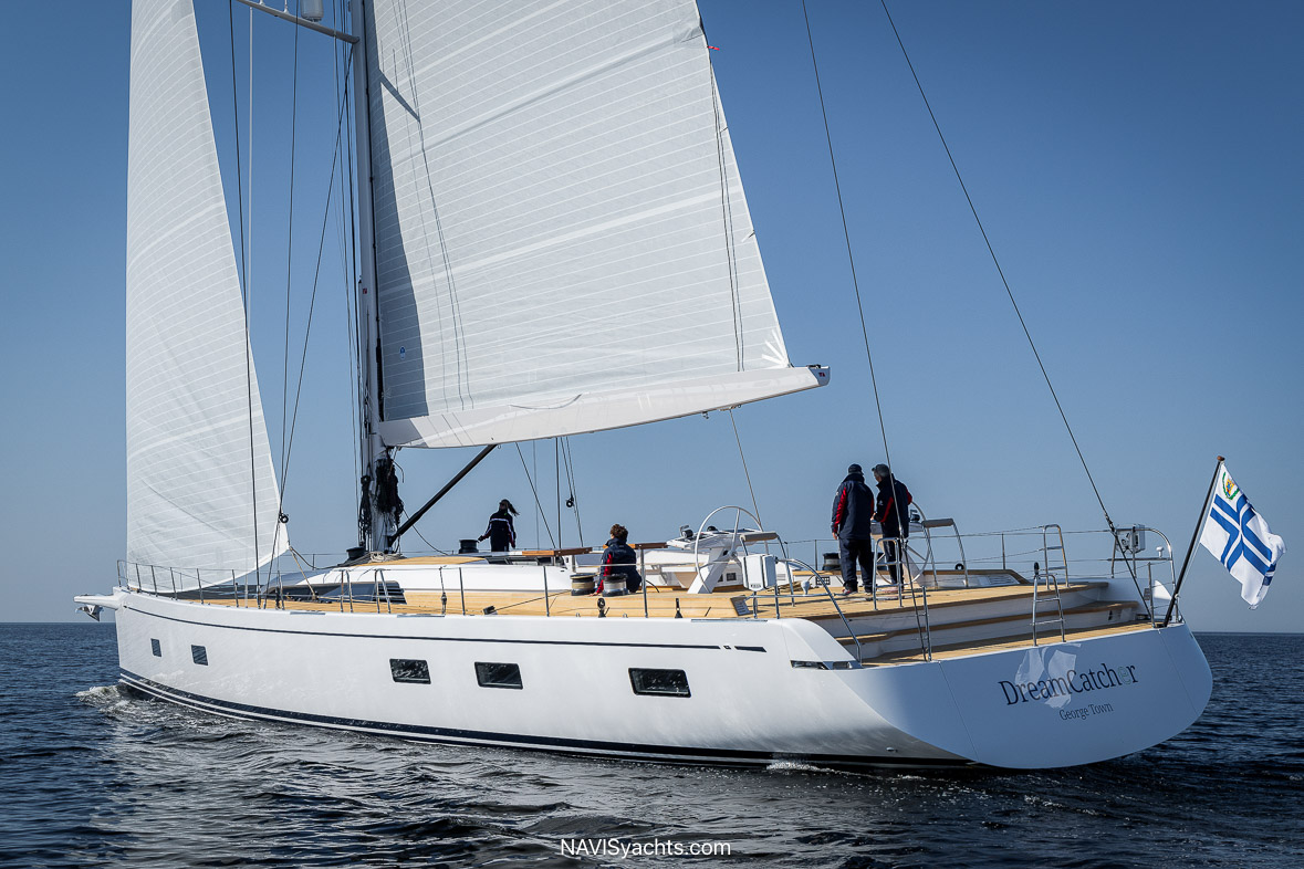 Nautor Swan’s Swan 88 Dreamcatcher sailing against a sunset backdrop, showcasing sleek lines and a teak deck.